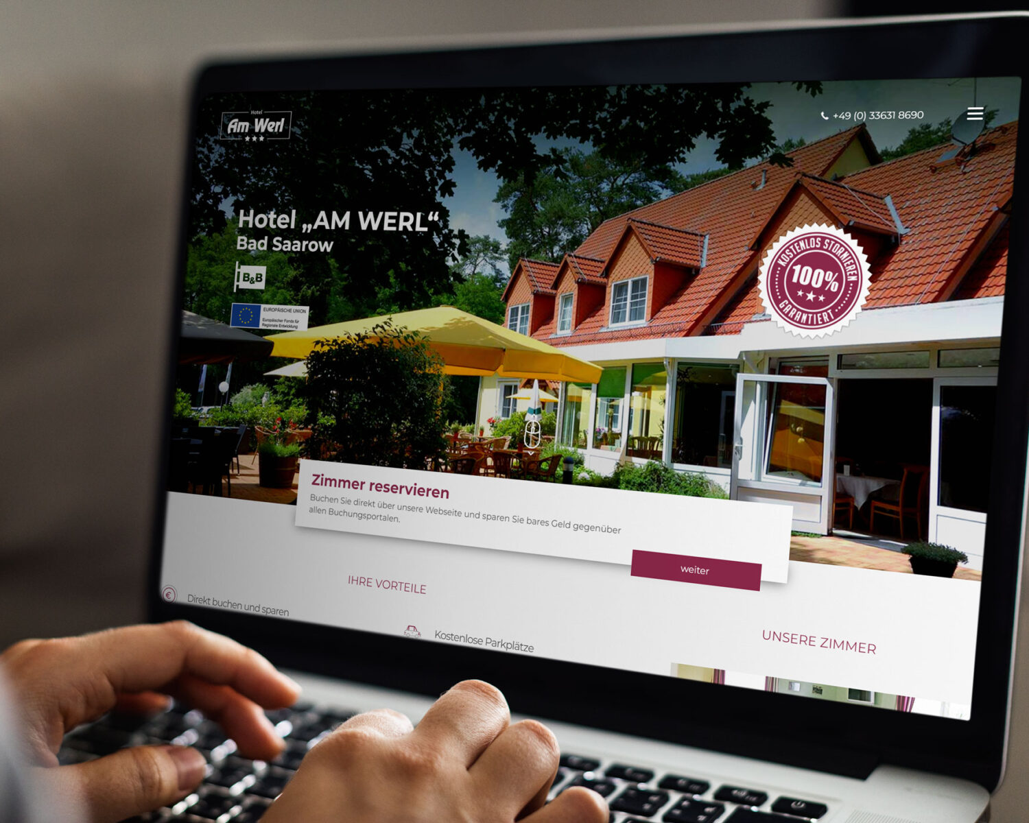 Ein Benutzer reserviert ein Zimmer auf der Website des Hotels „AM WERL“ in Bad Saarow, umgeben von Natur.