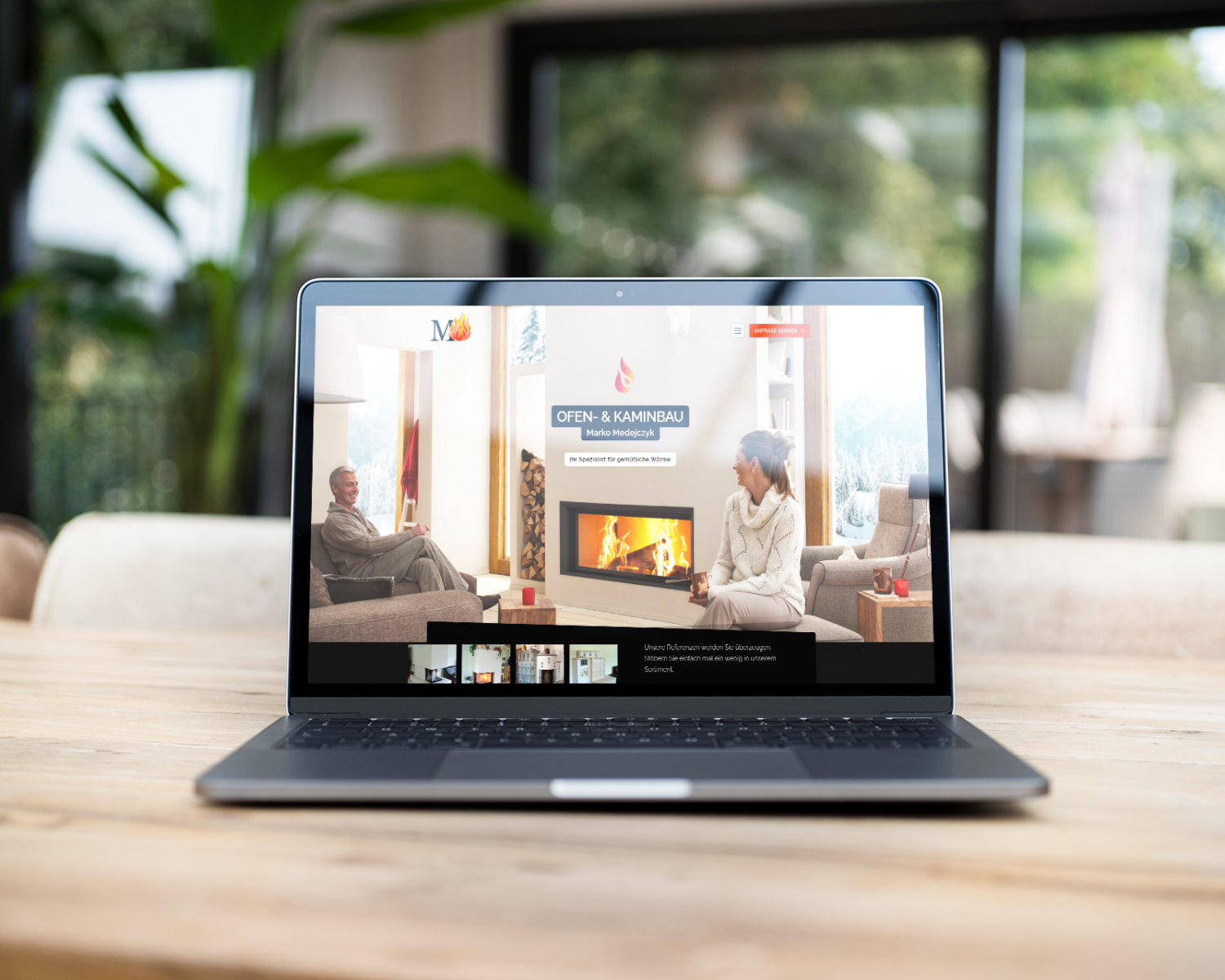Ein Laptop zeigt eine Webseite über Öfen und Kamine, während zwei Personen in einem gemütlichen Raum sitzen.